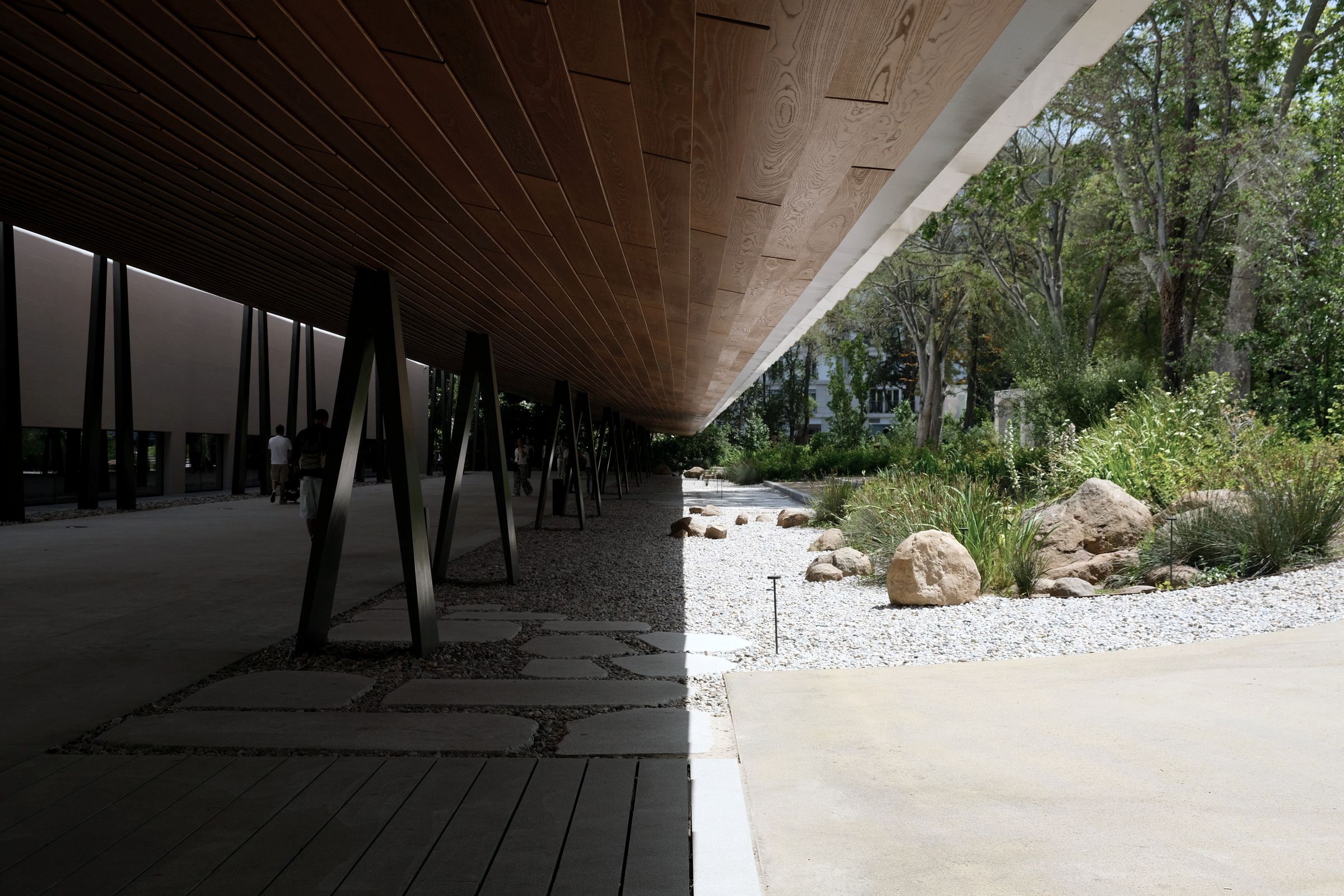A building on columns above a garden, seen from below.