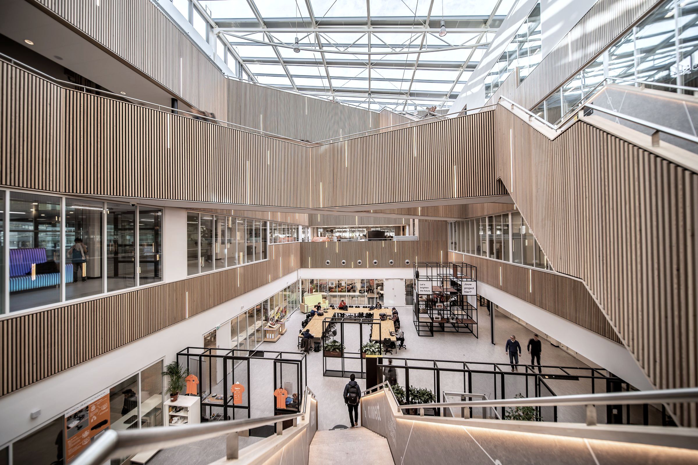 A glazed atrium over several floors, with people small on the galleries below.